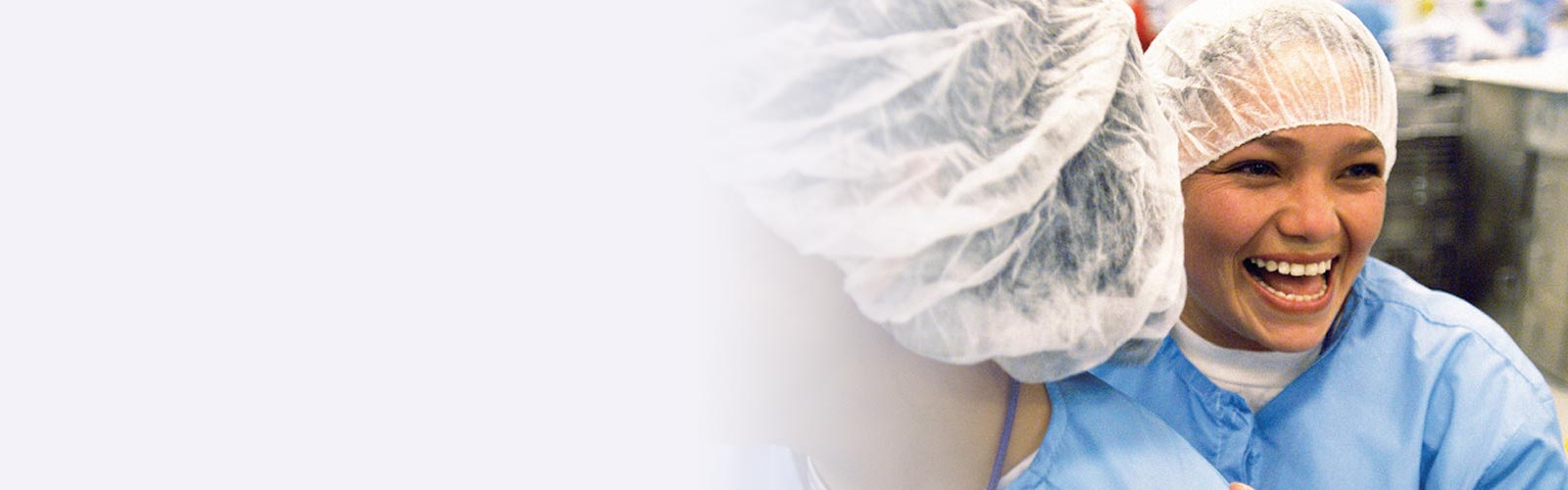 two women laughing in factory.